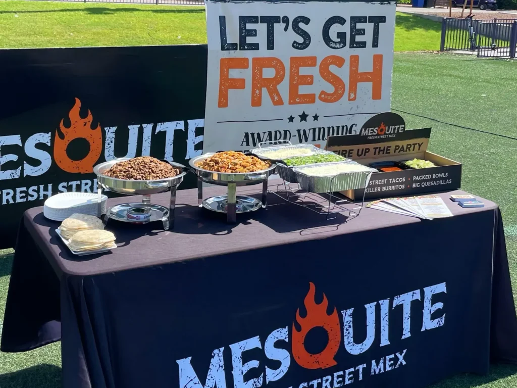 Mesquite taco bar catering set up outdoors at an apartment community event