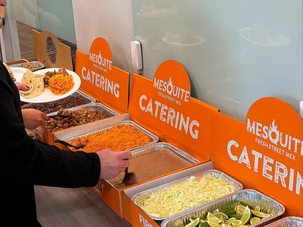 Guests serving themselves from a Mesquite taco bar catering line at an office